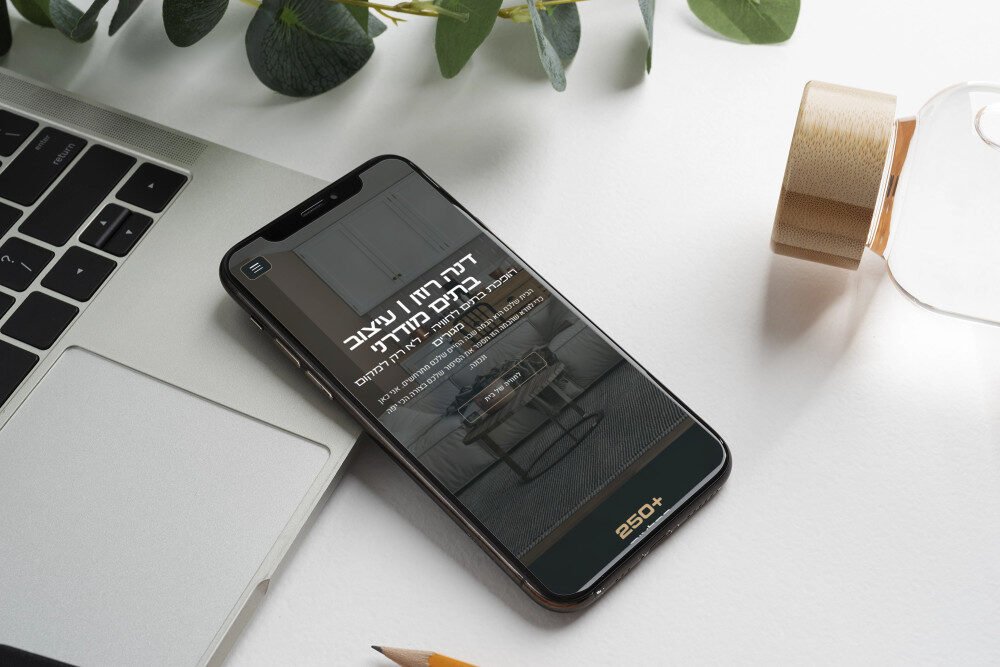 סביבת שולחן עבודה אלגנטית מציגה את אתר חדיש על מכשיר נייד.