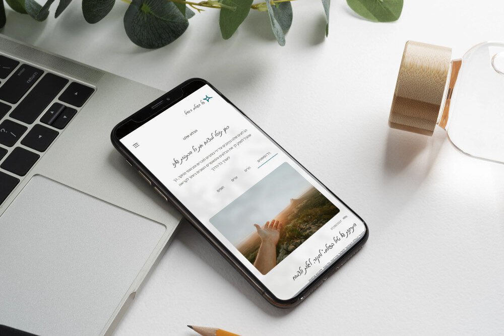 סביבת שולחן עבודה אלגנטית מציגה את אתר חדיש על מכשיר נייד.